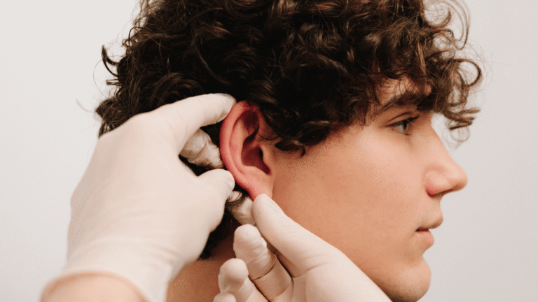 Doctor revisando la oreja de un paciente durante una valoración de otoplastia en Toledo