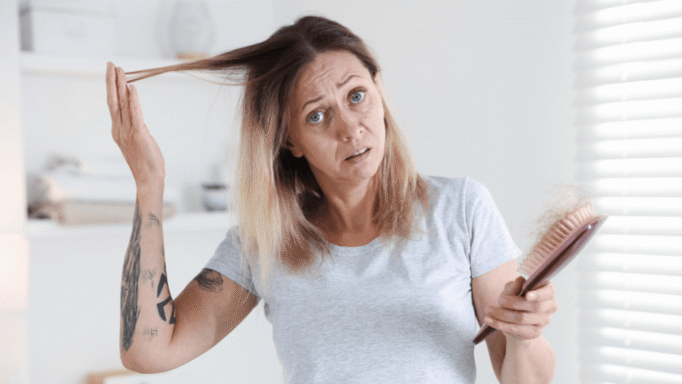 Mujer mayor de 40 observando pérdida de densidad capilar frente al espejo