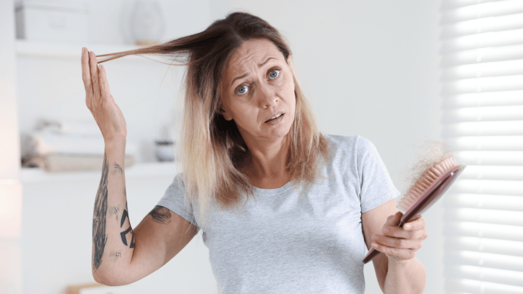 Mujer mayor de 40 observando pérdida de densidad capilar frente al espejo