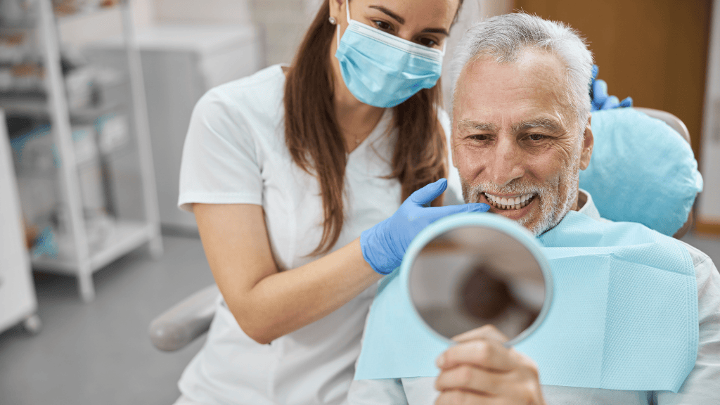 Paciente sonriendo frente al espejo tras tratamiento de implantes dentales en Toledo